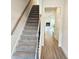 Hallway view featuring carpeted stairs and an open view of the living room with fireplace at 145 Scarlett Place Dr, Bowdon, GA 30108