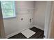 Functional laundry room with vinyl floors, a window, and a shelf at 145 Scarlett Place Dr, Bowdon, GA 30108