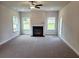 Bright living room showcasing a modern fireplace, neutral carpet, and ample natural light at 145 Scarlett Place Dr, Bowdon, GA 30108