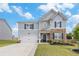Charming two-story home featuring a stone facade, inviting front porch, well-maintained lawn, and attached two car garage at 36 Ivy Chase Loop, Dallas, GA 30157