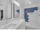 Modern bathroom with double vanity, sleek mirrors, and a walk-in shower with blue accent tile at 63 Lakeview Ln, Stockbridge, GA 30281