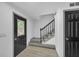Bright hallway showcasing a staircase with black railing and front door with decorative glass at 63 Lakeview Ln, Stockbridge, GA 30281