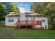 Backyard view of the home's exterior and wooden deck, surrounded by green lawn and trees at 9444 Lakeview Ct, Douglasville, GA 30135