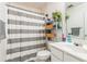 Well-lit bathroom features a shower-tub combo with curtain and mirrored vanity with storage at 9444 Lakeview Ct, Douglasville, GA 30135