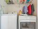 Convenient laundry room area with washer and dryer units and wire shelving for storage at 9444 Lakeview Ct, Douglasville, GA 30135
