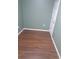 Green painted bedroom featuring warm brown laminate flooring and a white painted door at 1988 Greensferry Gln, Lawrenceville, GA 30043