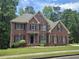 Beautiful two-story brick home showcases classic architectural details and mature landscaping at 1988 Greensferry Gln, Lawrenceville, GA 30043