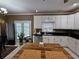 Well-lit kitchen featuring white cabinetry, black countertops and a wooden center island at 1988 Greensferry Gln, Lawrenceville, GA 30043