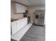 Well-lit kitchenette with stainless steel refrigerator, oven, and white cabinets at 1988 Greensferry Gln, Lawrenceville, GA 30043