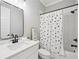 Charming bathroom featuring a shower-tub combo and a sleek, dark-finished vanity at 2243 Cain Cir, Dacula, GA 30019