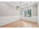Bright dining room featuring wainscoting, a modern light fixture, and large window at 2243 Cain Cir, Dacula, GA 30019