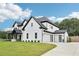 Stunning exterior showcasing a well-manicured lawn and a three car garage with modern doors at 2243 Cain Cir, Dacula, GA 30019