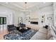 Spacious living room with a modern fireplace, built-in shelving, hardwood floors, and coffered ceilings at 2243 Cain Cir, Dacula, GA 30019