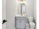 This half bathroom features a gray vanity, gold hardware, and a framed mirror at 2243 Cain Cir, Dacula, GA 30019