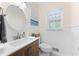 Charming bathroom featuring a vanity with a vessel sink, wainscotting, and a round mirror at 4522 Reva Ne Ct, Marietta, GA 30066