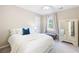 Bright bedroom featuring a cozy bed with white bedding, neutral walls, and a vintage-style mirrored armoire at 4522 Reva Ne Ct, Marietta, GA 30066