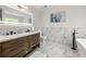 Bright bathroom featuring double sinks, marble accents, and a sleek, modern design with a soaking tub at 900 Ira Sw St, Atlanta, GA 30310