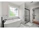 This bathroom offers a modern tub next to a window and a sleek glass enclosed shower with marble accents at 900 Ira Sw St, Atlanta, GA 30310