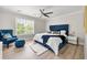 Stylish bedroom features a blue upholstered bed, soft lighting, and a cozy chair with an ottoman, offering a tranquil space at 900 Ira Sw St, Atlanta, GA 30310
