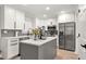 Bright kitchen featuring stainless steel appliances, white cabinets, and a gray island with a white countertop at 900 Ira Sw St, Atlanta, GA 30310