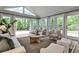 Inviting sunroom filled with natural light features neutral-toned furniture, a rug, and views of the wooded yard at 270 Hollyridge Way, Roswell, GA 30076
