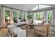 Sun-drenched sunroom with a vaulted ceiling and large windows overlooking the green backyard at 270 Hollyridge Way, Roswell, GA 30076