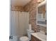 Cozy bathroom featuring unique brick-like wallpaper and a shower with a curtain at 8566 Jamestown Way, Jonesboro, GA 30238