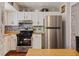Well-lit kitchen with white cabinets, stainless steel appliances, and butcher block countertops at 8566 Jamestown Way, Jonesboro, GA 30238