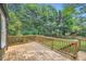 A wooden back deck with a railing, overlooking a spacious lawn and verdant trees at 1134 Jefferson Ave, East Point, GA 30344