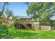 Backyard view of house with deck. The large green lawn is surrounded by trees at 1134 Jefferson Ave, East Point, GA 30344