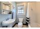 Cozy bathroom with a pedestal sink, toilet, and a shower-tub combo with a black and white curtain at 1134 Jefferson Ave, East Point, GA 30344