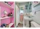 Bright bathroom with pink accents, open shelving, and a pedestal sink and a shower at 1134 Jefferson Ave, East Point, GA 30344