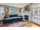 Bright living room with fireplace, hardwood floors, and comfortable blue sectional sofa at 1134 Jefferson Ave, East Point, GA 30344