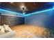 Finished basement with hardwood floors, dark painted ceiling with blue accent lighting at 119 Hardy Water Dr, Lawrenceville, GA 30045