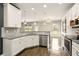 Bright kitchen with white cabinets, granite countertops, stainless steel appliances, and wood flooring at 119 Hardy Water Dr, Lawrenceville, GA 30045
