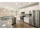 Open kitchen features stainless steel appliances, granite counters, tile backsplash, and modern lighting at 119 Hardy Water Dr, Lawrenceville, GA 30045