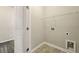 A functional laundry room with tile flooring and a wire shelf for organizing cleaning and washing supplies at 119 Hardy Water Dr, Lawrenceville, GA 30045