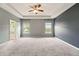 Spacious main bedroom with tray ceiling, ceiling fan, and neutral carpeting at 119 Hardy Water Dr, Lawrenceville, GA 30045