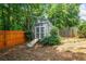 A storage shed featuring a ramp, set in a tree-filled backyard with wood fence at 2081 Township Dr, Woodstock, GA 30189