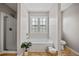 A renovated bathroom features a glass shower, soaking tub, decorative window, and tiled floors at 2081 Township Dr, Woodstock, GA 30189