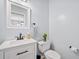 A half bathroom features a white vanity with black hardware and marble countertop, a toilet, and light blue paint at 2081 Township Dr, Woodstock, GA 30189