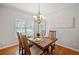 Bright dining room with hardwood floors, classic chandelier, and set table for four at 2081 Township Dr, Woodstock, GA 30189