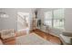 Bright living room featuring hardwood floors, comfortable seating, and a view of the staircase at 2081 Township Dr, Woodstock, GA 30189