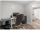 Home office with wood-look flooring, desk, chair, storage and view to a full bathroom with white shower curtain at 2081 Township Dr, Woodstock, GA 30189