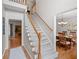 Traditional staircase featuring carpeted steps, wooden handrail, and views into dining and living spaces at 2081 Township Dr, Woodstock, GA 30189