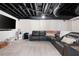 Finished basement with black exposed ceiling, a TV and a large sectional couch at 410 Beechwood Ln, Woodstock, GA 30189