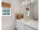 Bathroom with a single sink vanity with gold hardware, decorative mirror, and natural lighting at 410 Beechwood Ln, Woodstock, GA 30189