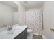 Bathroom featuring a shower with floral curtain, toilet and a vanity sink with dark cabinets at 410 Beechwood Ln, Woodstock, GA 30189