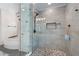 Modern bathroom with a glass enclosed shower, pebble floor, and elegant fixtures at 410 Beechwood Ln, Woodstock, GA 30189