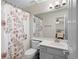Bathroom view showcasing a floral shower curtain, a sink and vanity with gray cabinetry at 410 Beechwood Ln, Woodstock, GA 30189